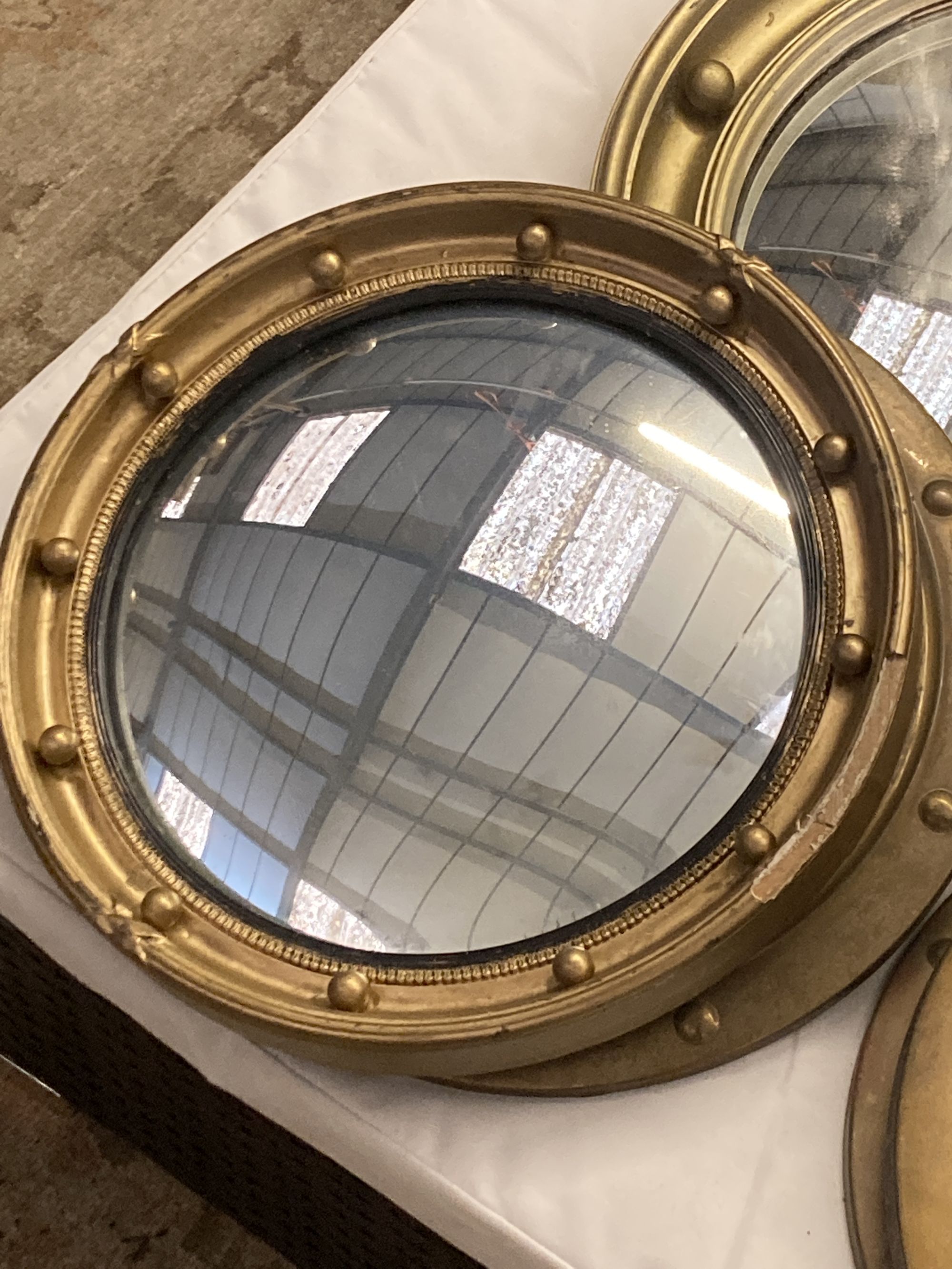 Six circular gilt and brass framed convex wall mirrors, largest 39cm diameter